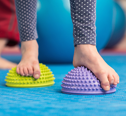 child practising balance and co-ordination in paediatric physiotherapy session